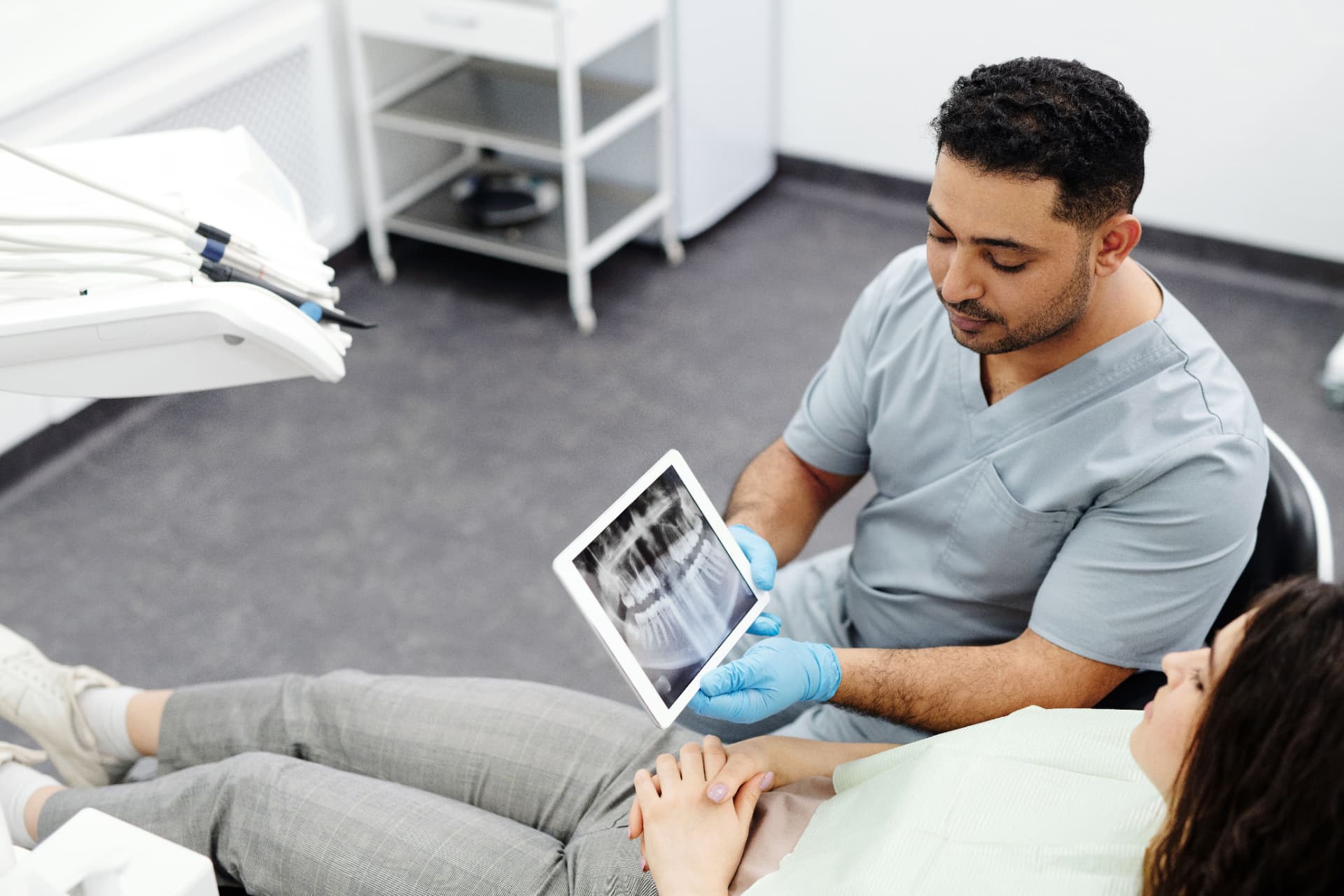 Dentist explaining an X-ray on a tablet to a patient at Harbour Dental